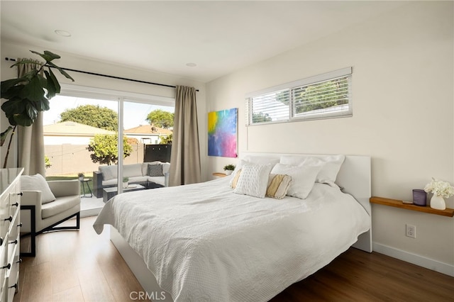 bedroom with wood finished floors, baseboards, and access to outside
