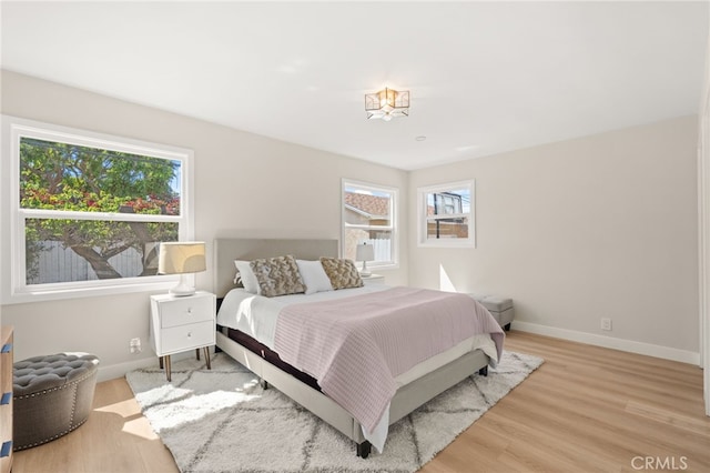 bedroom featuring baseboards and light wood finished floors