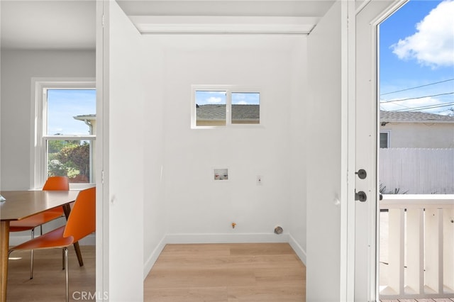 laundry area featuring light wood-style floors, washer hookup, baseboards, and laundry area