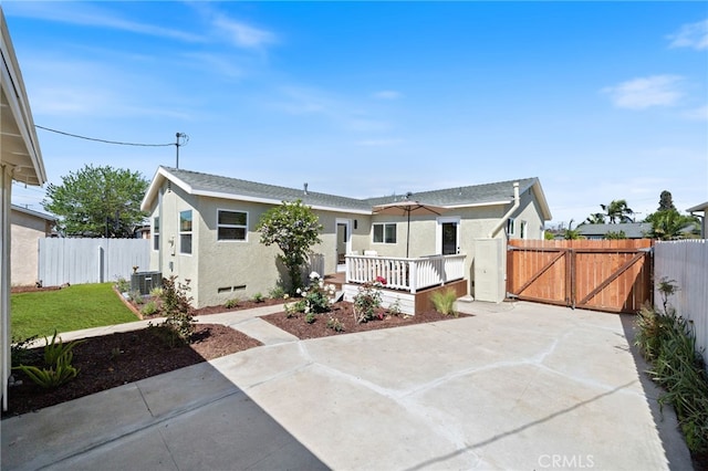 view of front facade featuring a gate, a fenced backyard, and stucco siding