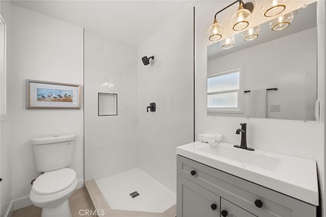 full bathroom featuring toilet, vanity, and tiled shower