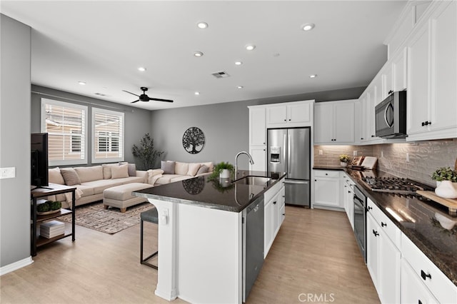 kitchen with stainless steel appliances, a sink, tasteful backsplash, visible vents, and recessed lighting