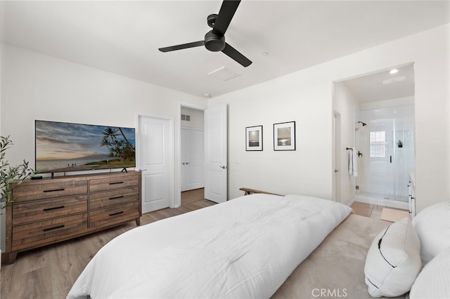 bedroom featuring light wood-style flooring, visible vents, connected bathroom, and a ceiling fan