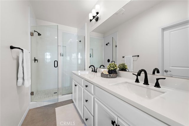 full bathroom featuring double vanity, a stall shower, and a sink