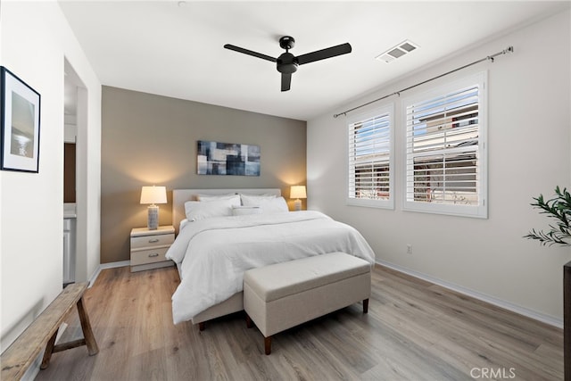 bedroom featuring light wood-type flooring, baseboards, a ceiling fan, and visible vents