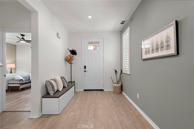 foyer entrance featuring visible vents, baseboards, wood finished floors, and ceiling fan