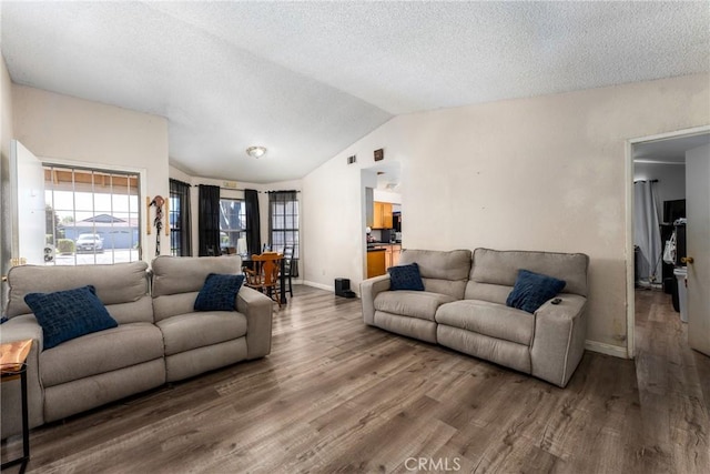 25448 Wedmore Dr, Moreno Valley, CA 92553 - living room featuring vaulted ceiling, wood finished floors, a textured ceiling, baseboards, and visible vents