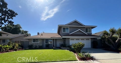 16591 Busby Ln, Huntington Beach, CA 92647 - traditional-style house featuring concrete driveway, a front yard, and a garage