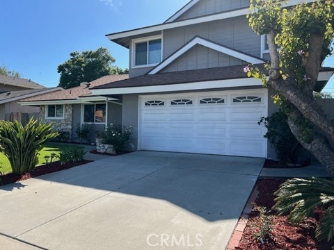 16591 Busby Ln, Huntington Beach, CA 92647 - view of front of house featuring driveway, a garage, and stone siding
