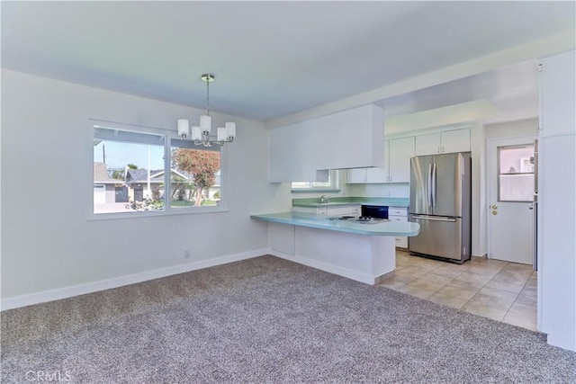 16591 Busby Ln, Huntington Beach, CA 92647 - kitchen featuring freestanding refrigerator, a chandelier, white cabinets, a sink, and light colored carpet