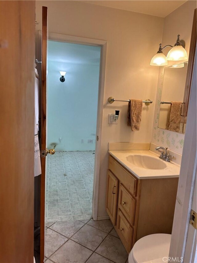 bathroom featuring toilet, vanity, and tile patterned flooring