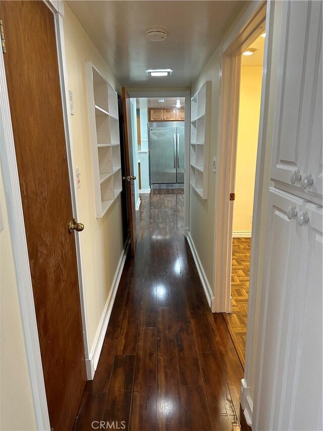 hall with baseboards and dark wood finished floors