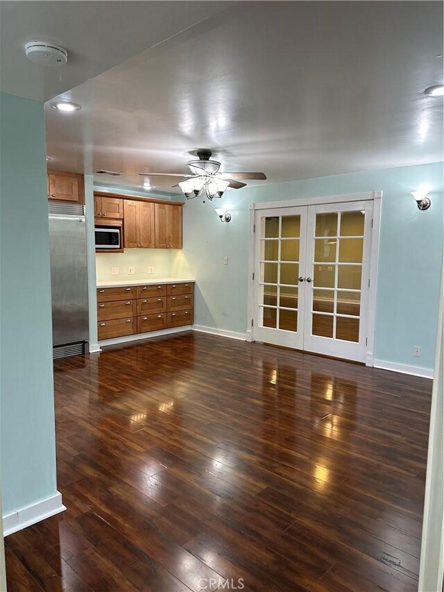 unfurnished living room with french doors, a ceiling fan, dark wood-style floors, and baseboards