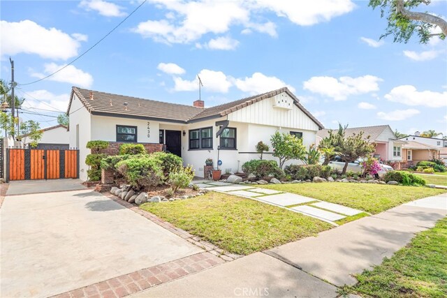 2430 Van Wick St, Inglewood, CA 90303 - view of front of house featuring a front lawn, a chimney, stucco siding, and a gate