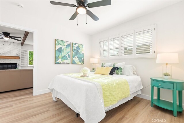 2430 Van Wick St, Inglewood, CA 90303 - bedroom with baseboards, wood finished floors, ceiling fan, and a brick fireplace