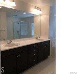 7076 Luminaire Ct, Eastvale, CA 92880 - bathroom with a stall shower, double vanity, and a sink