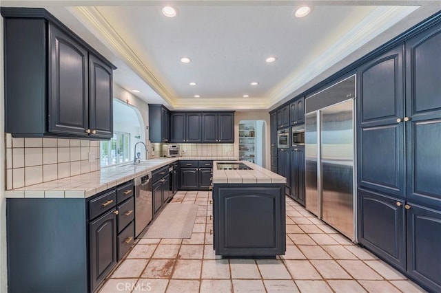 kitchen featuring decorative backsplash, tile counters, appliances with stainless steel finishes, and ornamental molding