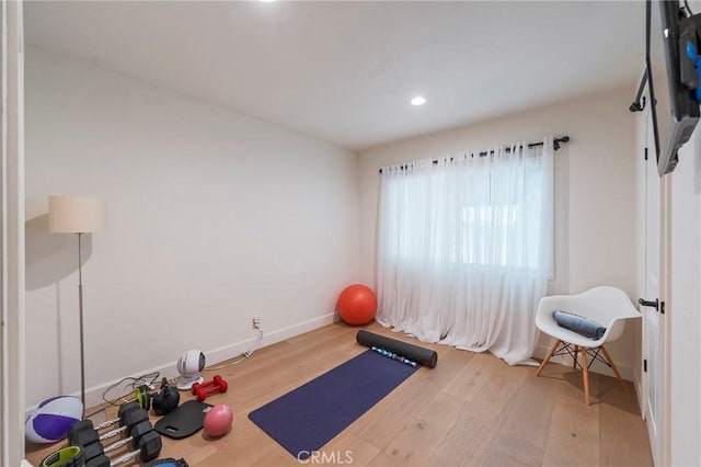 exercise area featuring recessed lighting, baseboards, and wood finished floors