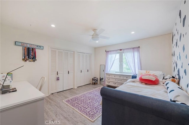 bedroom featuring light wood-style floors, recessed lighting, multiple closets, and ceiling fan
