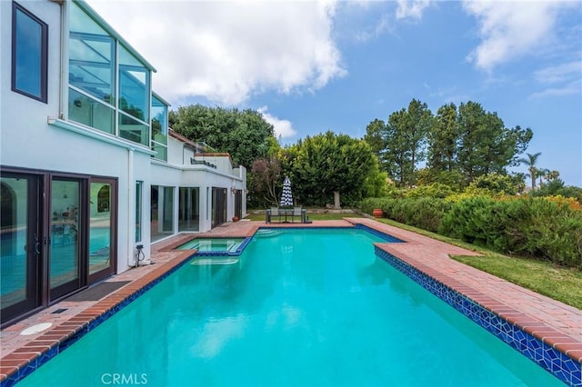 view of swimming pool with a pool with connected hot tub and a patio area