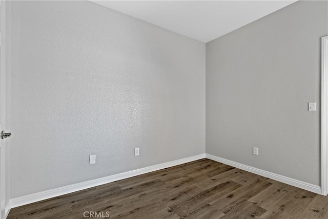 empty room featuring baseboards and wood finished floors