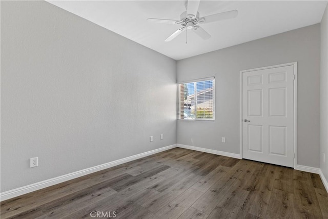 empty room with baseboards, ceiling fan, and wood finished floors