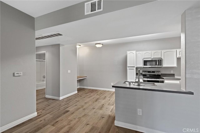 kitchen featuring visible vents, a sink, white cabinetry, and appliances with stainless steel finishes