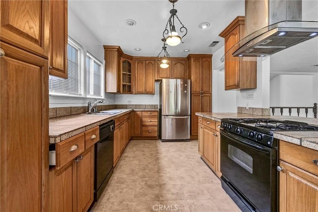 kitchen featuring wall chimney exhaust hood, a sink, brown cabinetry, black appliances, and hanging light fixtures