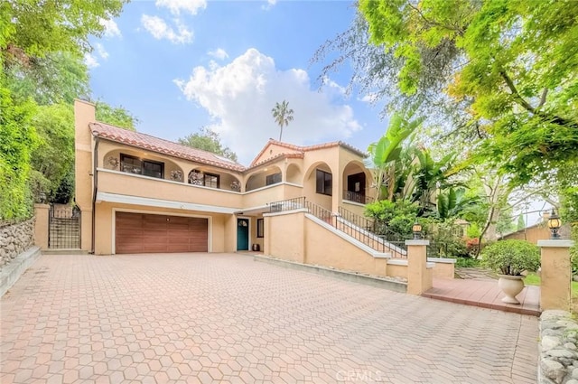 516 Orange Grove Ave, South Pasadena, CA 91030 - mediterranean / spanish house with a garage, stairway, decorative driveway, a balcony, and stucco siding