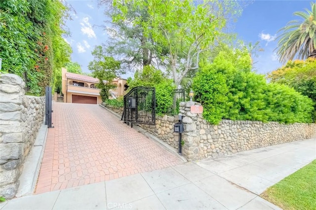 exterior space with stucco siding, fence, a gate, and a garage