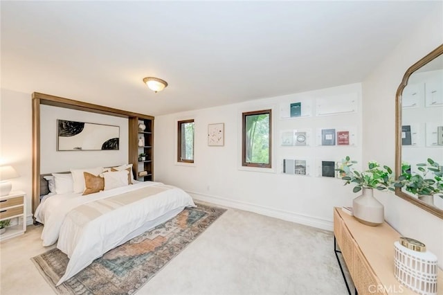 bedroom featuring baseboards and light carpet