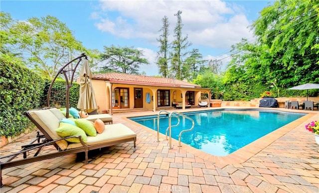 view of pool featuring a patio, french doors, and a fenced in pool