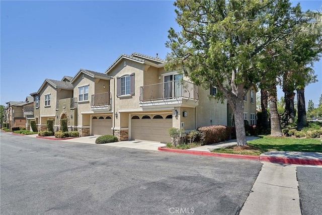 7353 Ellena W # 103, Rancho Cucamonga, CA 91730 - multi unit property with a garage, a balcony, stucco siding, a residential view, and concrete driveway