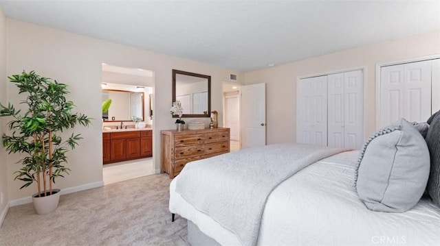 16001 Ballantine Ln, Huntington Beach, CA 92647 - bedroom featuring light carpet, multiple closets, and ensuite bath