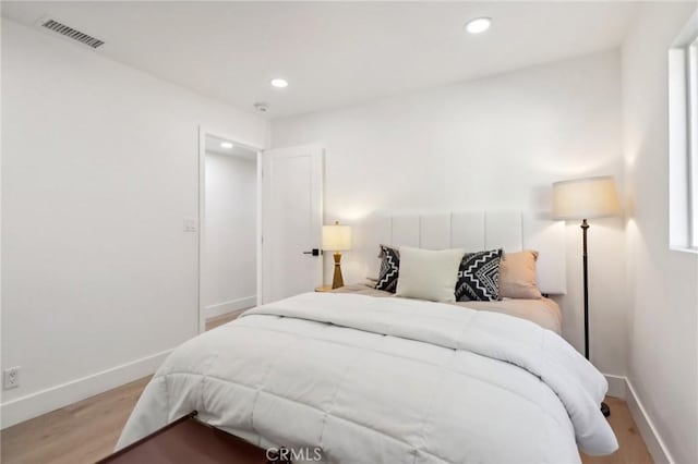 bedroom featuring baseboards, wood finished floors, visible vents, and recessed lighting
