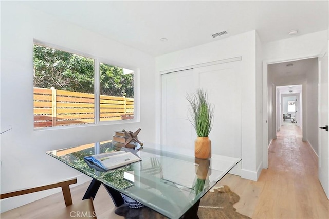 dining area featuring light wood-style floors, visible vents, and baseboards