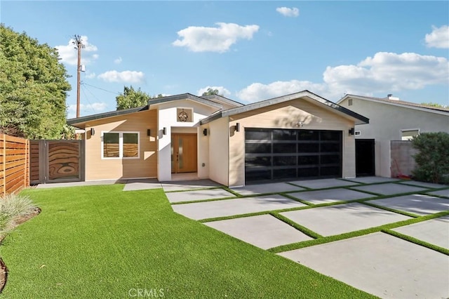 contemporary house featuring fence, stucco siding, an attached garage, driveway, and a front yard