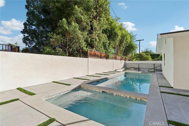 view of pool featuring a fenced in pool, a patio, a fenced backyard, and an in ground hot tub