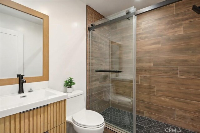 bathroom featuring a stall shower, vanity, and toilet