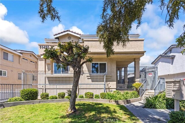 11415 216th St Unit 24, Lakewood, CA 90715 - bungalow-style home with stucco siding, a front yard, a tiled roof, and fence