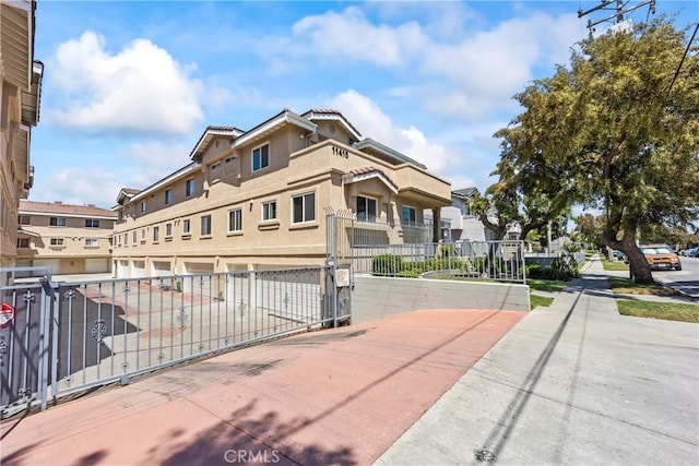 11415 216th St Unit 24, Lakewood, CA 90715 - view of front facade with a residential view, stucco siding, and fence