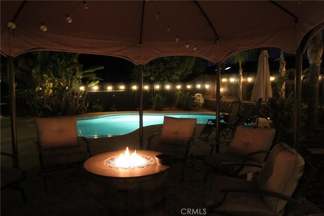 2653 Ashcroft Ave, Clovis, CA 93611 - pool at night with a patio, an outdoor fire pit, and a fenced in pool