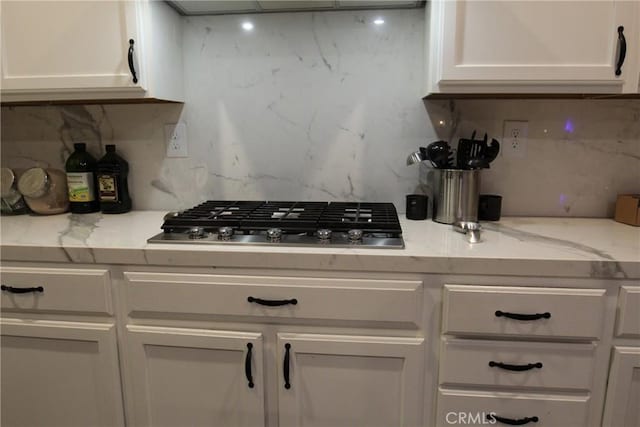 2653 Ashcroft Ave, Clovis, CA 93611 - kitchen with white cabinets, stainless steel gas cooktop, light stone countertops, and decorative backsplash