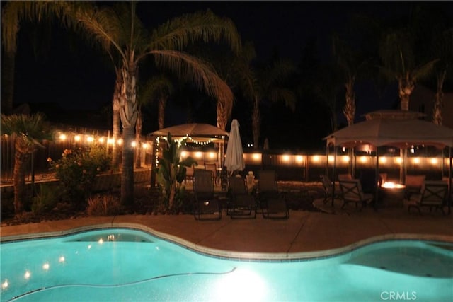 2653 Ashcroft Ave, Clovis, CA 93611 - pool at night featuring a gazebo, an outdoor pool, and a patio area
