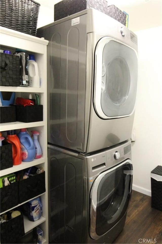 2653 Ashcroft Ave, Clovis, CA 93611 - laundry room featuring baseboards, stacked washer and clothes dryer, dark wood-style flooring, and laundry area