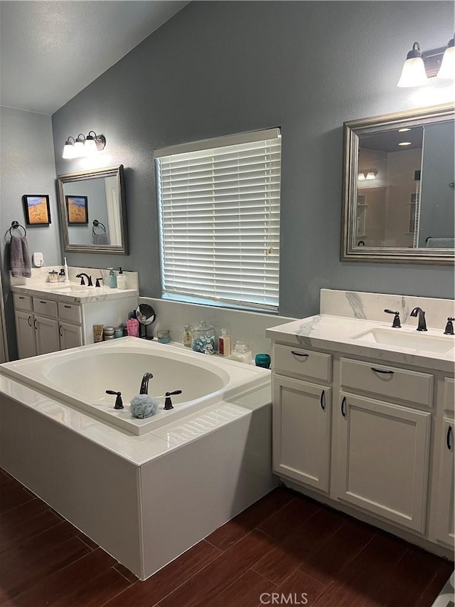 2653 Ashcroft Ave, Clovis, CA 93611 - bathroom featuring wood finished floors, a bath, and a sink