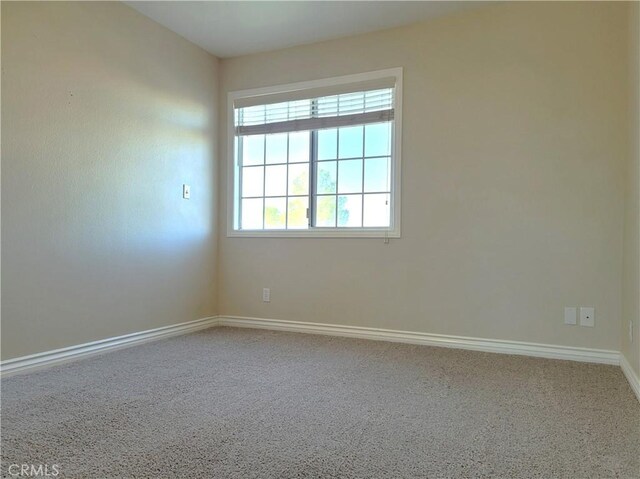 carpeted spare room with baseboards
