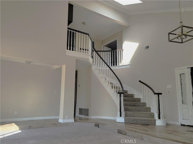 interior space featuring visible vents, high vaulted ceiling, an inviting chandelier, and baseboards
