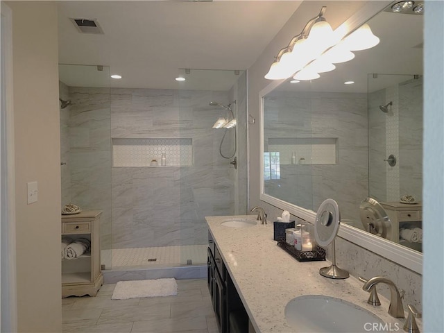 full bath with visible vents, a marble finish shower, marble finish floor, and a sink