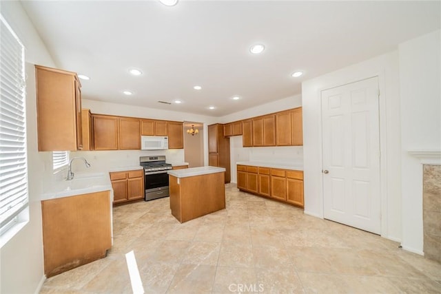 36877 Meadow Brook Way, Beaumont, CA 92223 - kitchen featuring white microwave, gas range, light countertops, a sink, and a center island